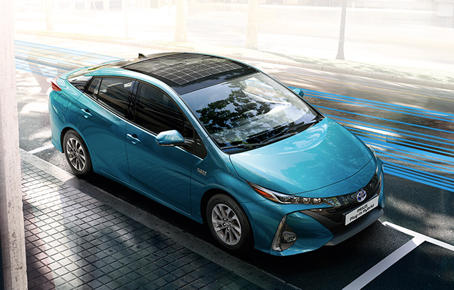 Červená Toyota Prius během jízdy